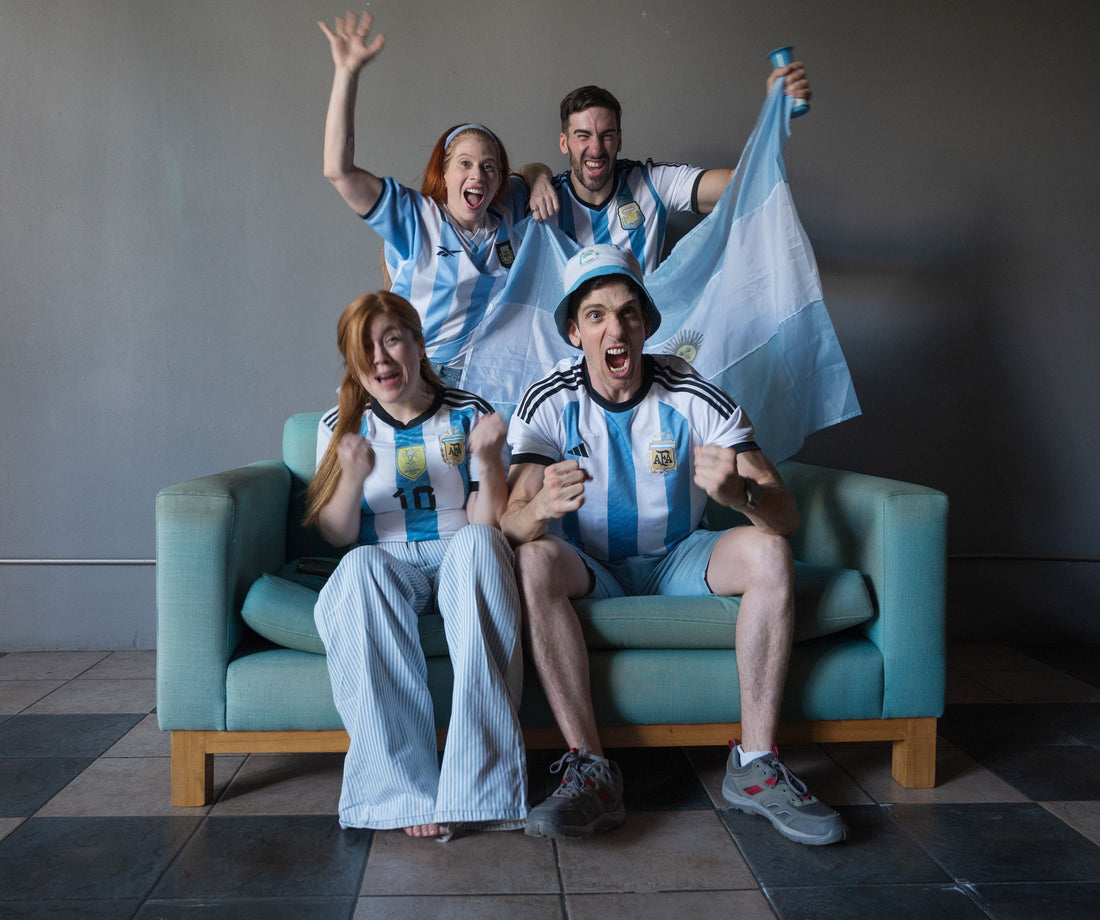 Argentine football supporters watching a match together at home.