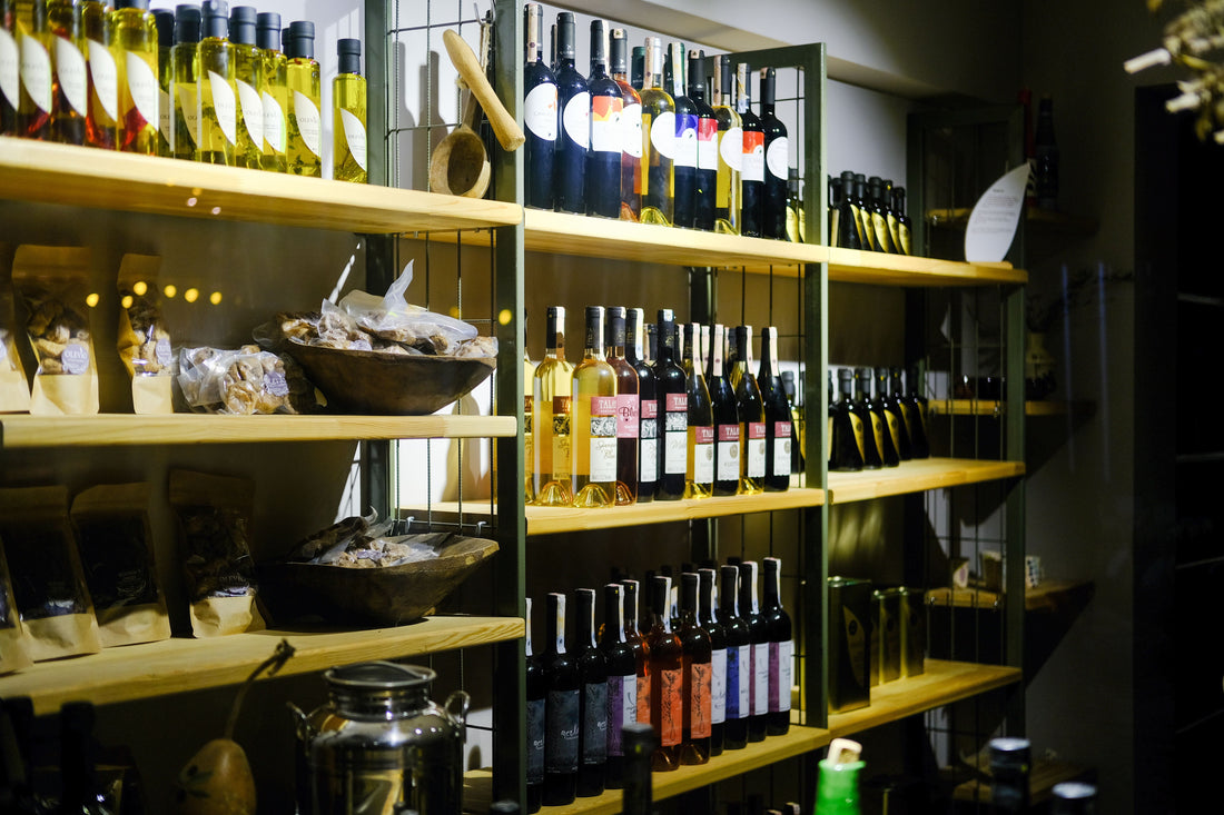 A varied selection of wine bottles displayed on wooden shelves in a wine shop.