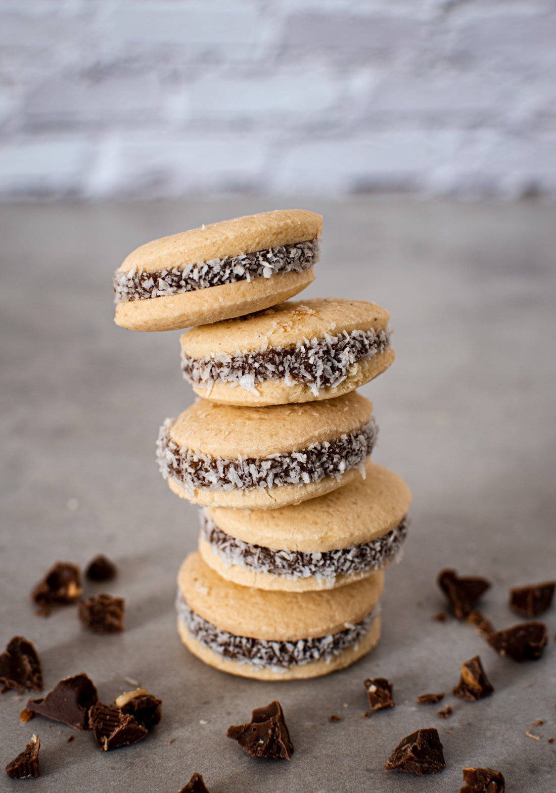 A stack of traditional Argentinian alfajores with dulce de leche and coconut.