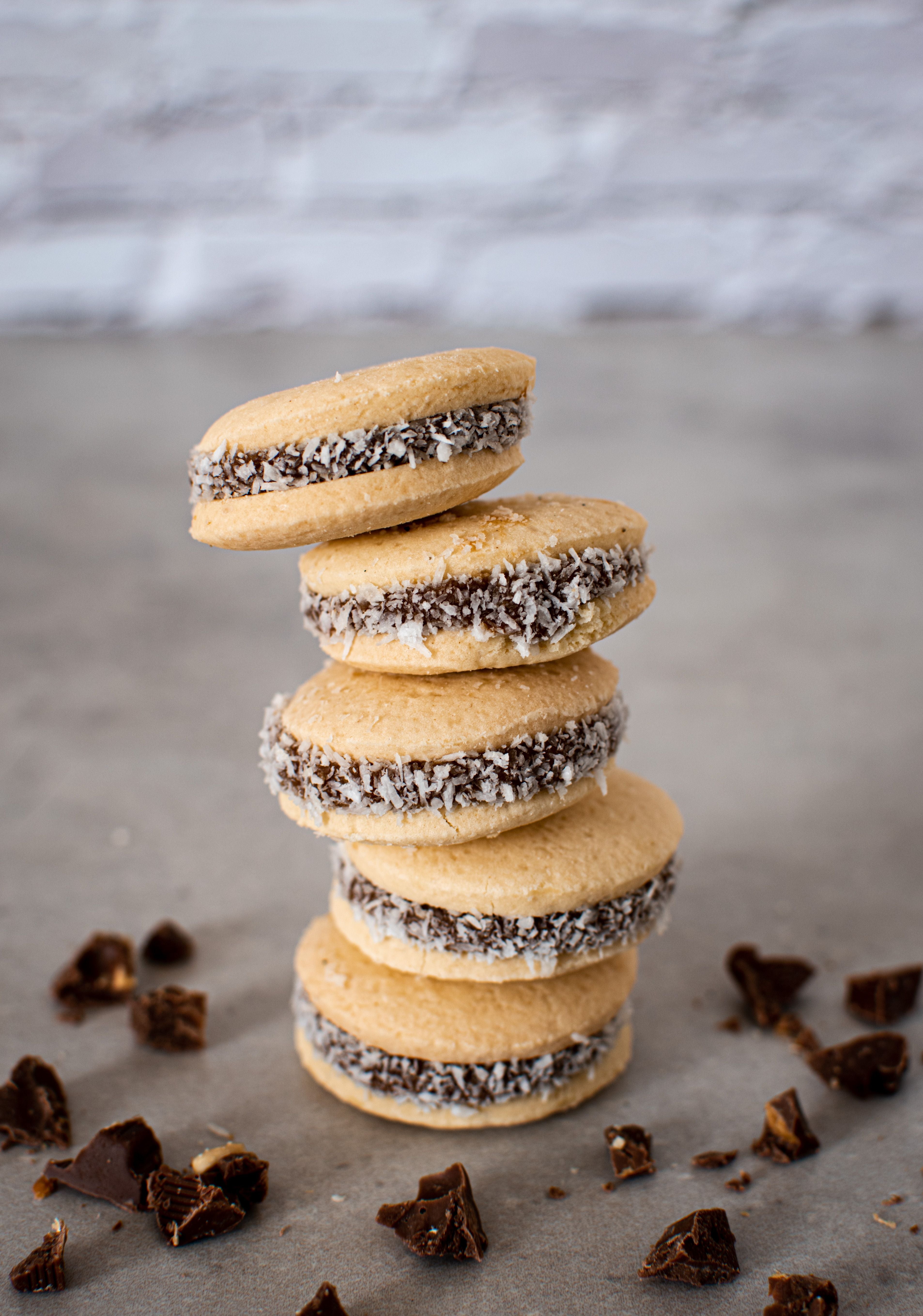 A stack of traditional Argentinian alfajores with dulce de leche and coconut.