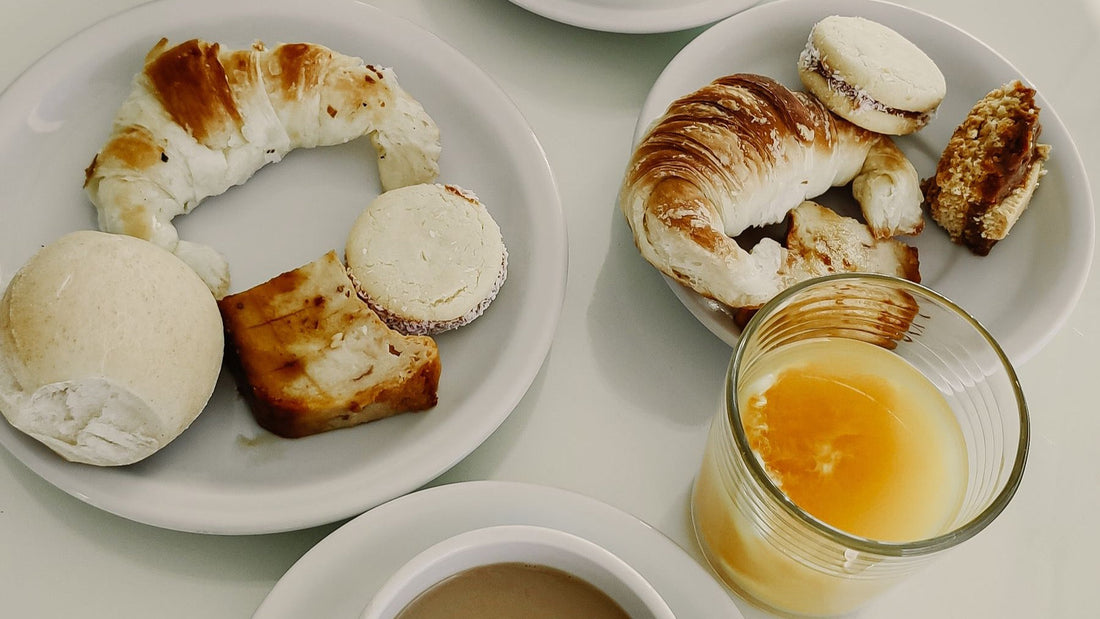 Coffee, orange juice, croissants and alfajores are arranged for a traditional Argentinian breakfast.