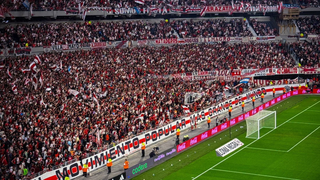 A packed stand of River Plate supporters fills Estadio Monumental during a night match in Buenos Aires.