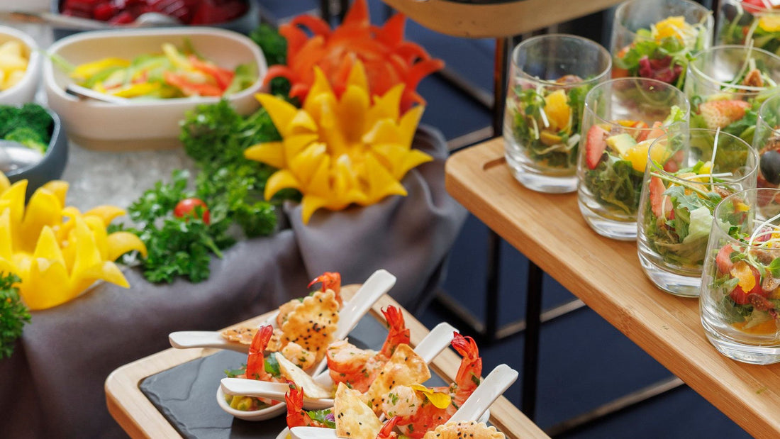 Individual salads, vegetables and seafood appetisers are arranged for a catered gathering.