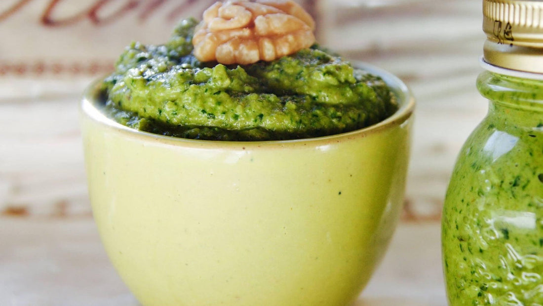 A bowl and bottle of vivid green pesto illustrate the texture and colour of herb-based sauces.