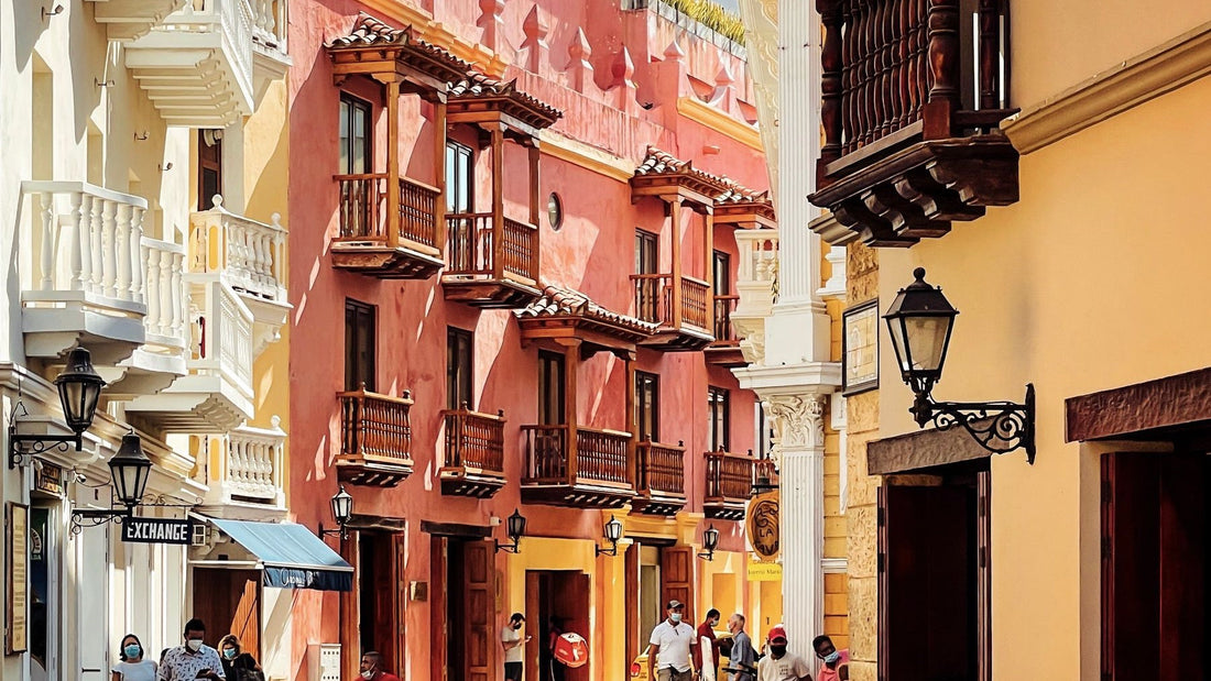 Colourful colonial balconies line a sunlit street in Cartagena, Colombia.