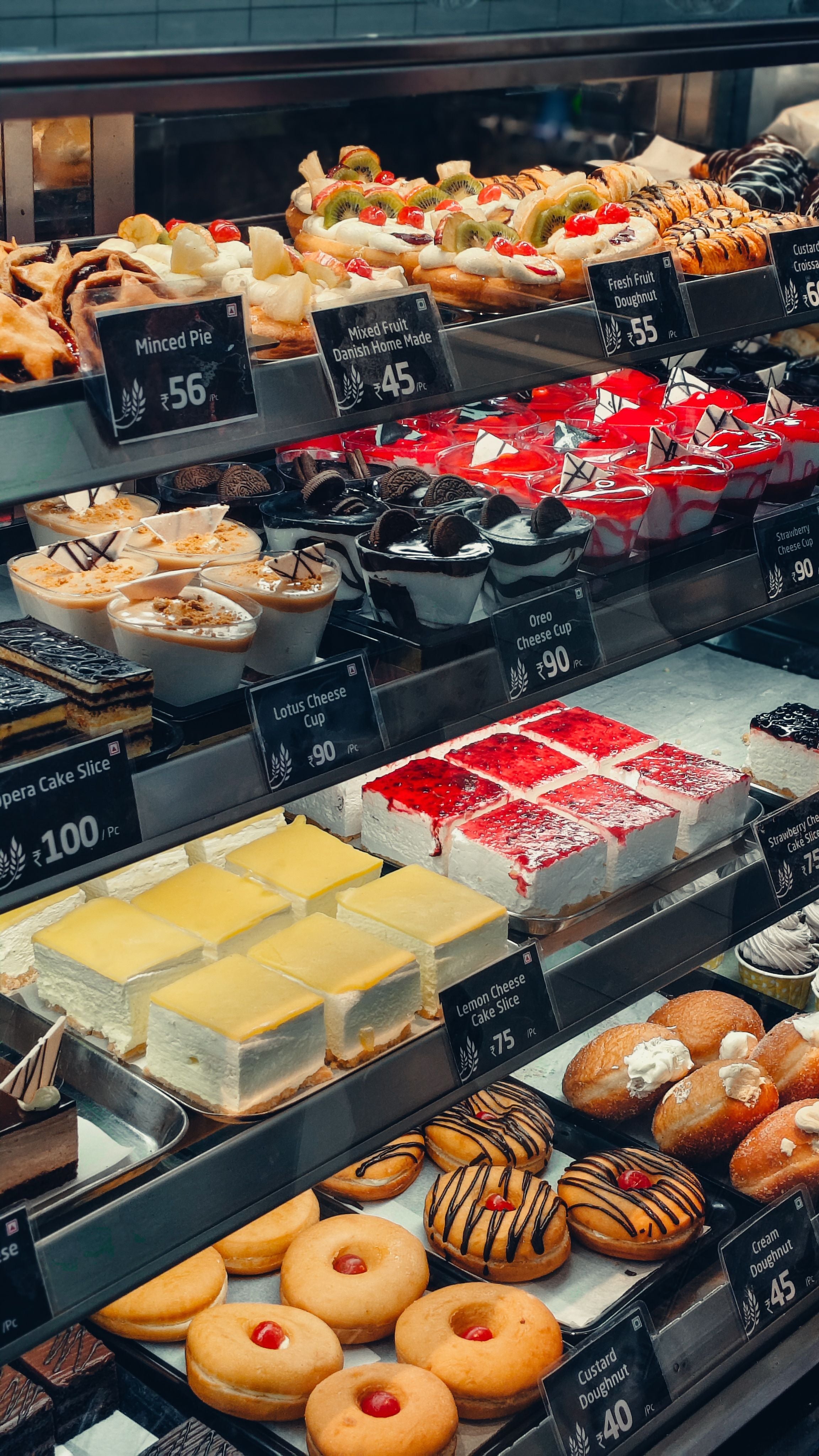 A varied selection of freshly baked pastries is displayed at an artisan bakery.