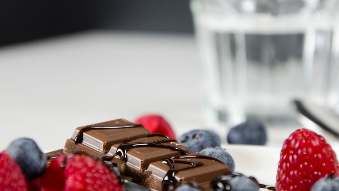 Fresh raspberries, blueberries and pieces of chocolate are arranged for a berry-and-chocolate taste comparison.