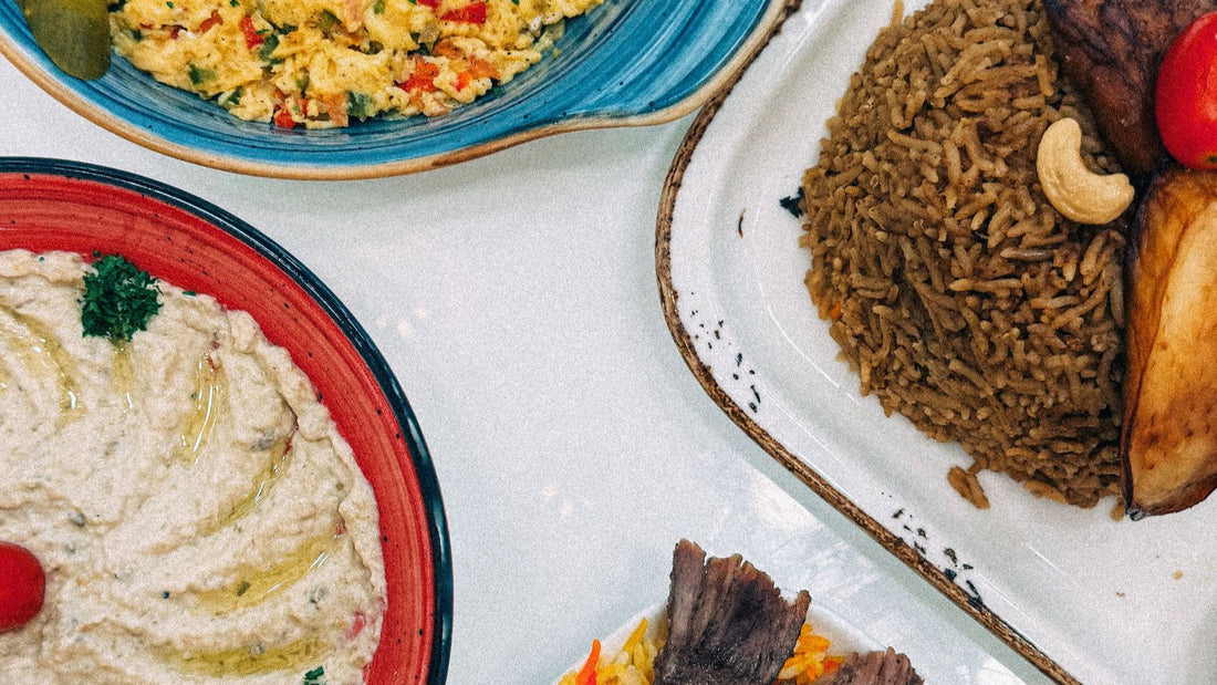 Rice, hummus, grilled meat and colourful side dishes form a generous Middle Eastern catering spread.