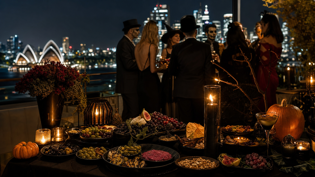 Elegant adult Halloween party with dark grazing table, candles, pumpkins and costumed guests overlooking Sydney Harbour.