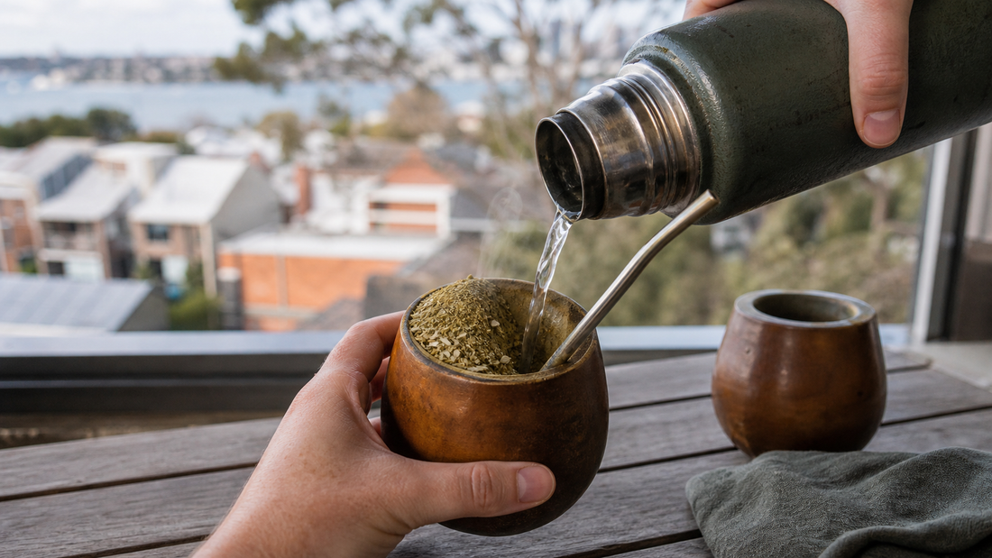 Warm water is poured into the low hollow beside the bombilla while dry yerba remains mounded on the opposite side of a wooden mate gourd.