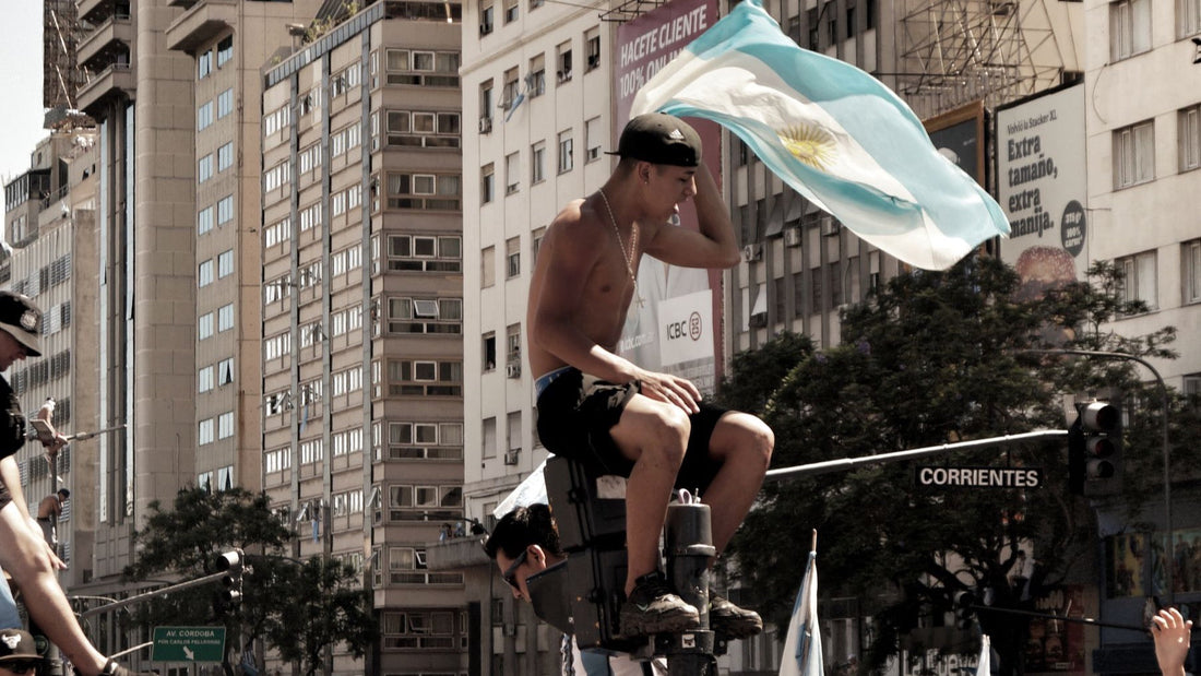 A crowd gathers beneath an Argentine flag on Avenida Corrientes in Buenos Aires.