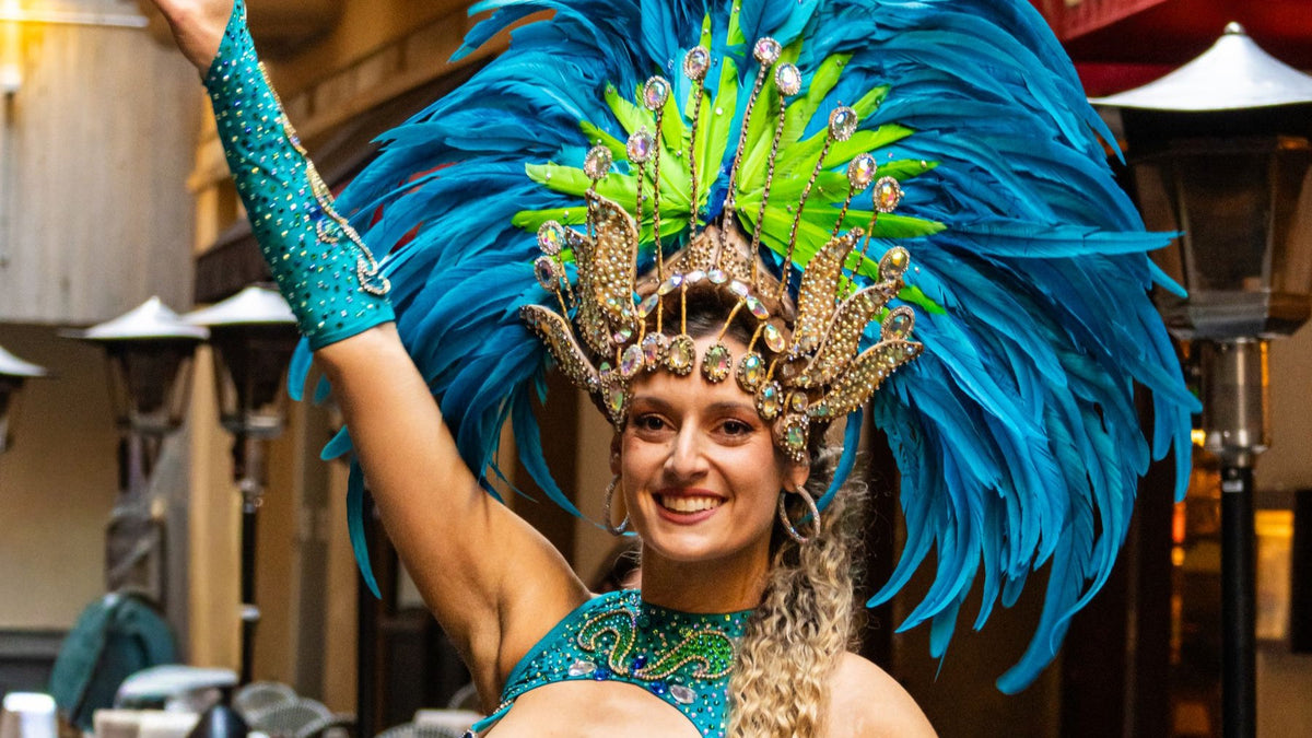A carnival dancer in a blue feathered costume performs during a colourful Sydney street festival.
