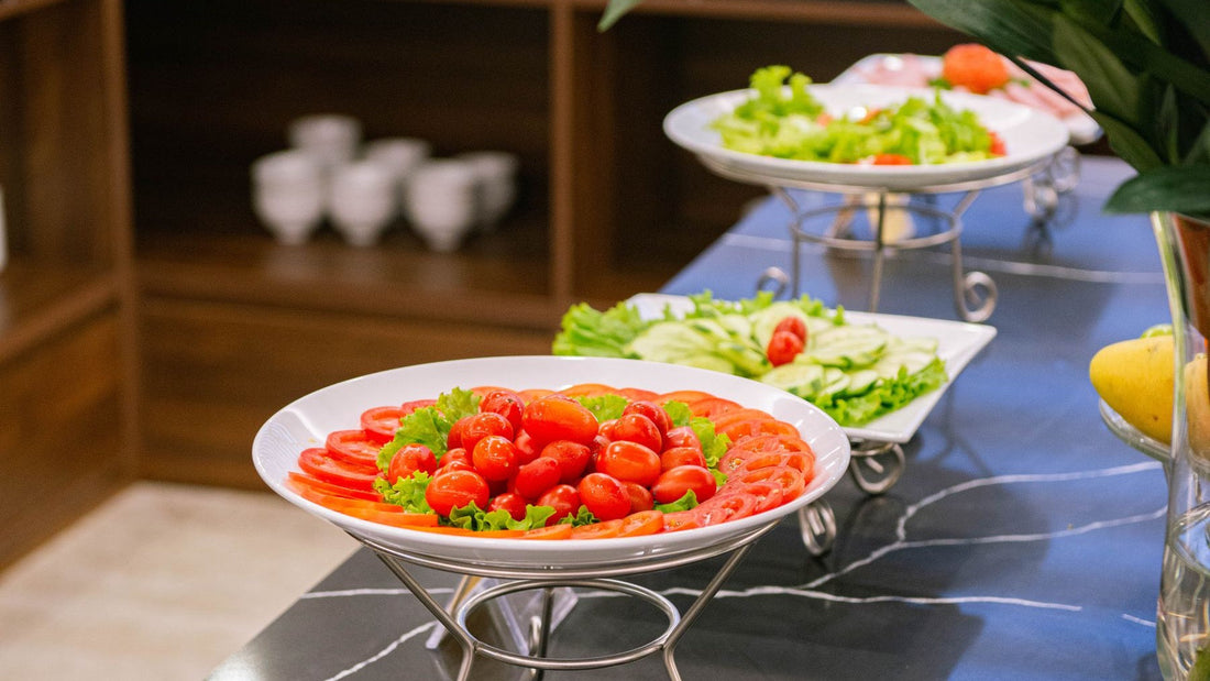 Tomato, cucumber and green salads are arranged across a fresh vegetarian buffet.