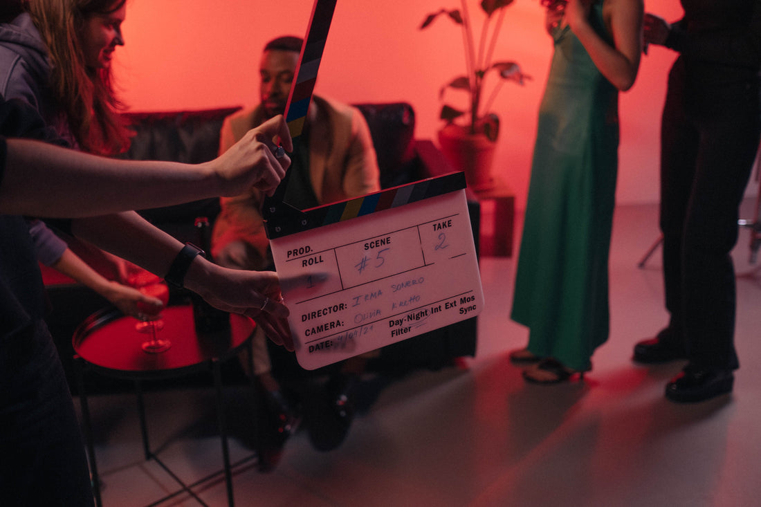 A film clapperboard is held ready on a professional movie set.