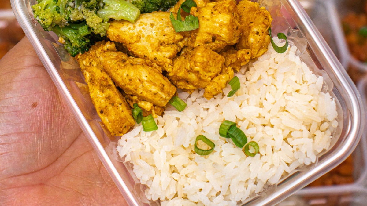 Chicken, rice and broccoli are portioned into containers as part of a winter freezer meal-prep session.