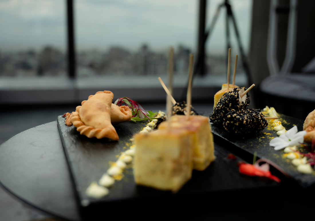 Premium finger food catering platter with empanadas on black slate board with Sydney Harbour view, perfect for boat parties, corporate events and birthday catering in Sydney