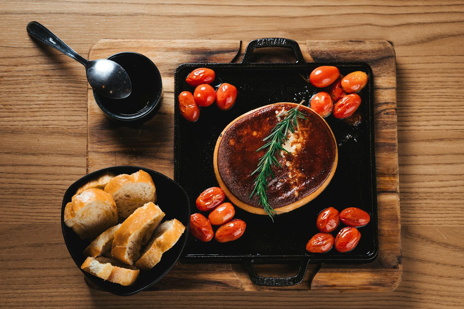 Provoleta — baked provolone cheese with cherry tomatoes, rosemary and bread