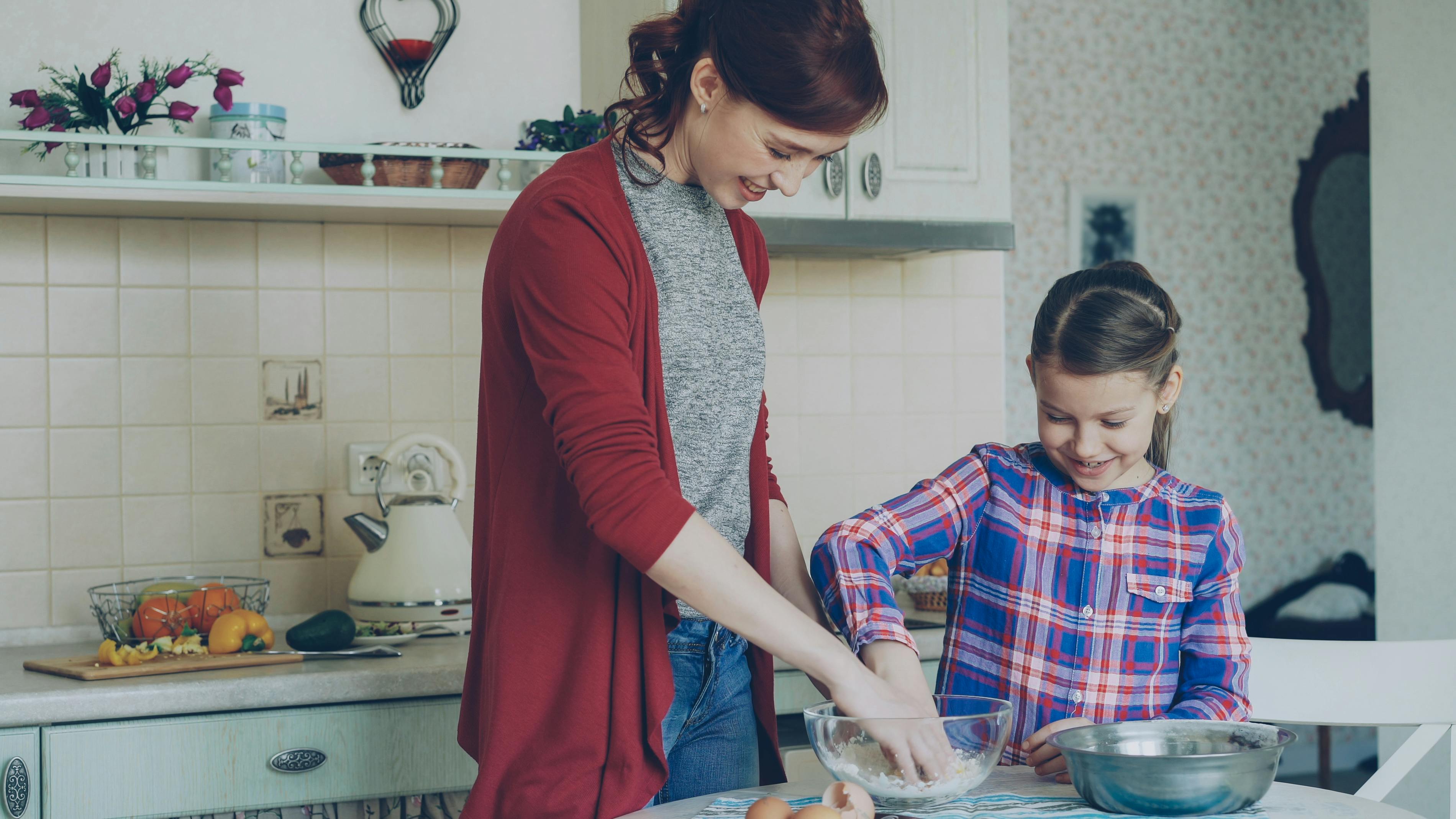 Mother and daughter cooking empanadas together in the kitchen